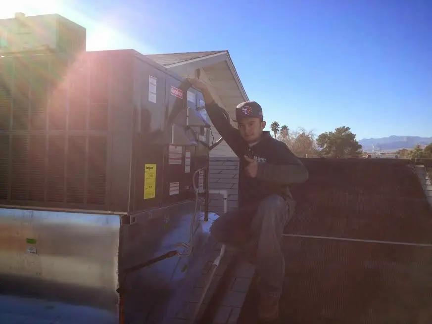 HVAC technician performing AC Tune-Up on a rooftop unit in Chapel Hill